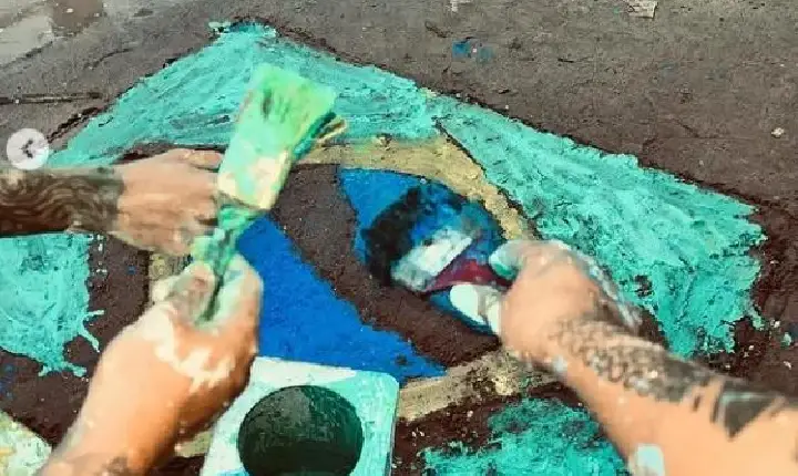 Jovens desenham bandeira do Brasil em rua de lama em Belém